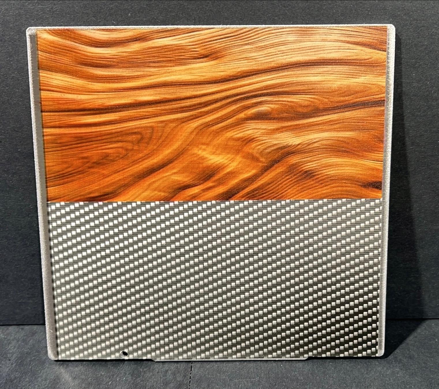 Wood-grain and carbon-fiber appearances UV-printed directly onto an aluminum aircraft-panel sample.